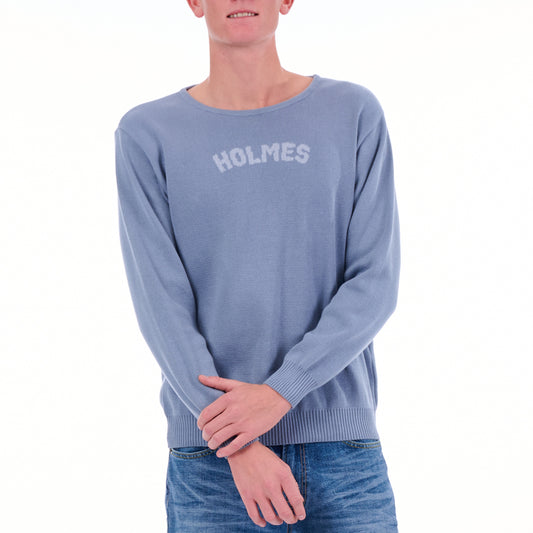 Person wearing a blue sweater with 'HOLMES' text on a white background