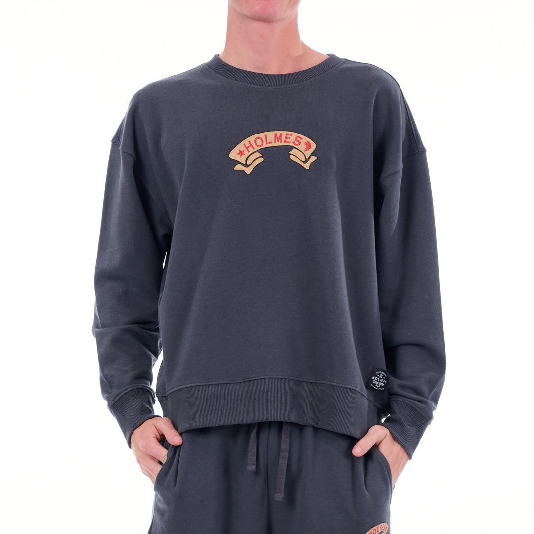 Person wearing a dark gray sweatshirt with 'HOLMES' logo on a white background