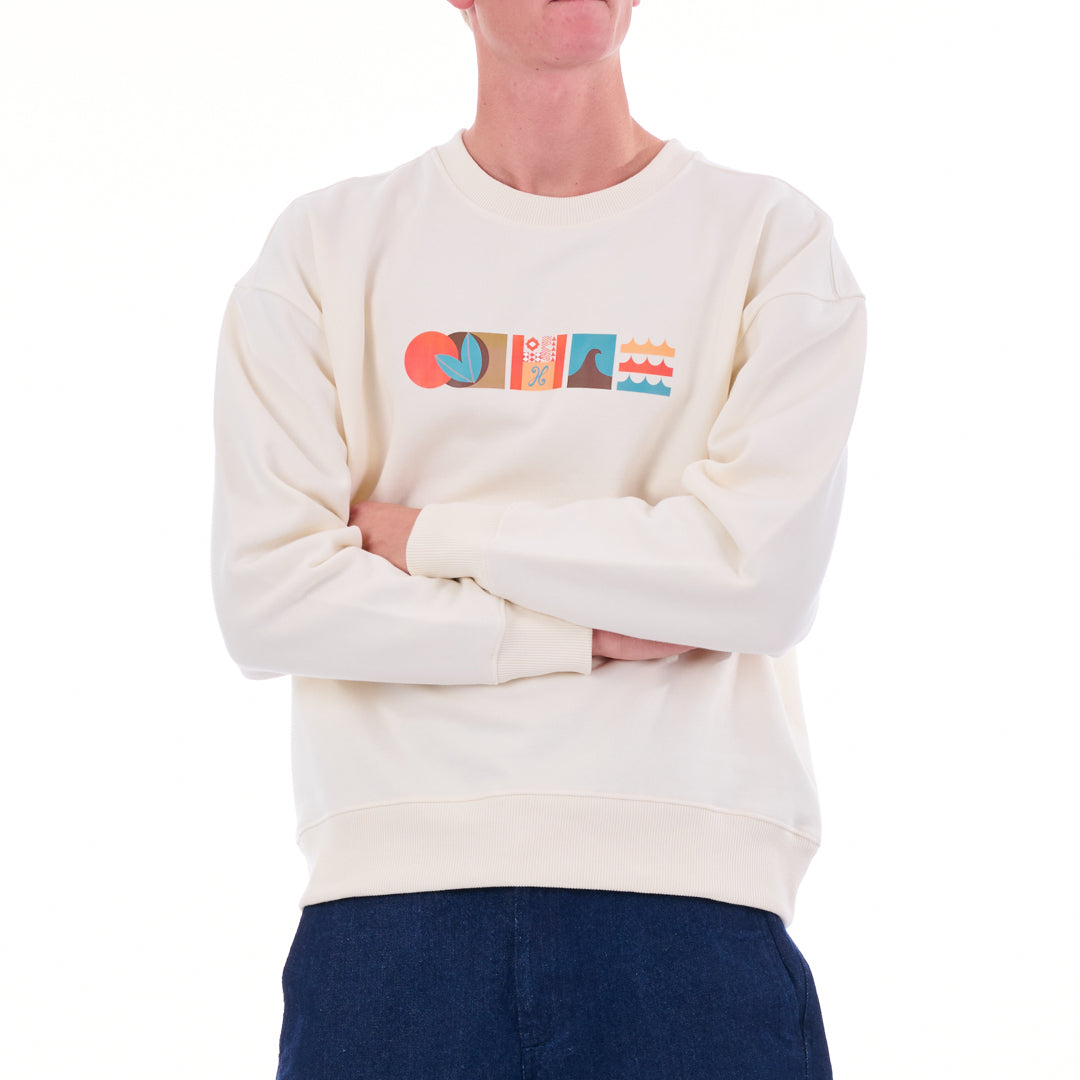 Person wearing a cream sweatshirt with colorful graphics on a white background