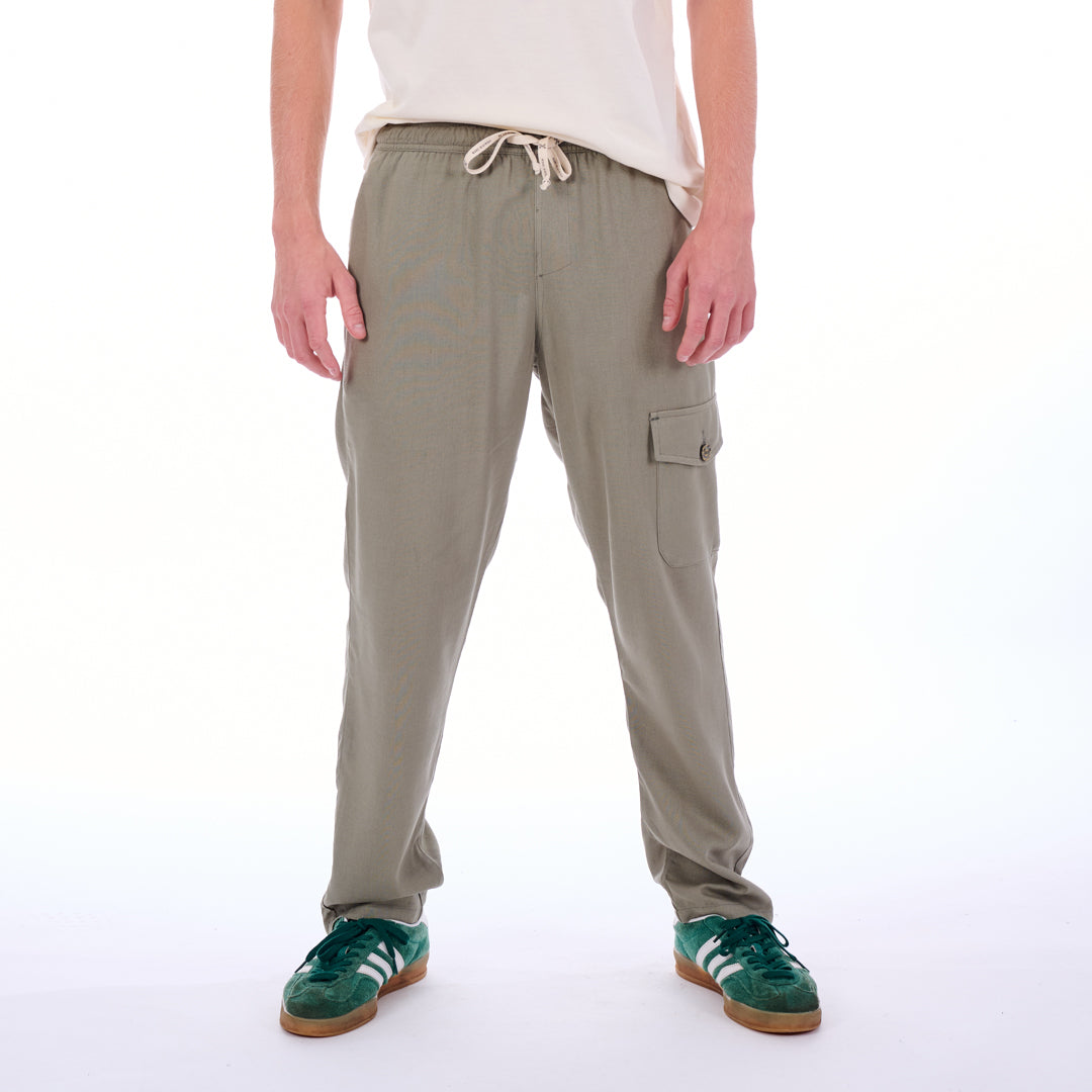 Person wearing beige cargo pants on a white background