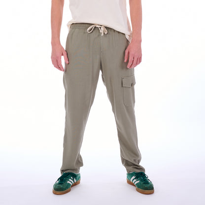 Person wearing beige cargo pants on a white background