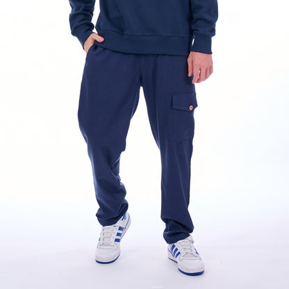 Person wearing a navy tracksuit with white sneakers on a white background