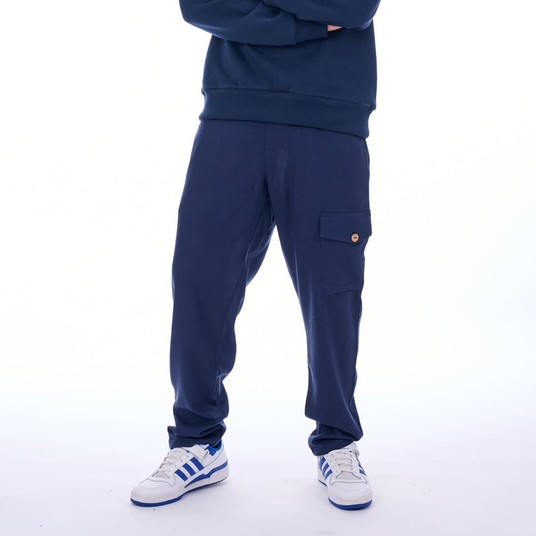 Person wearing a navy tracksuit with white sneakers on a white background