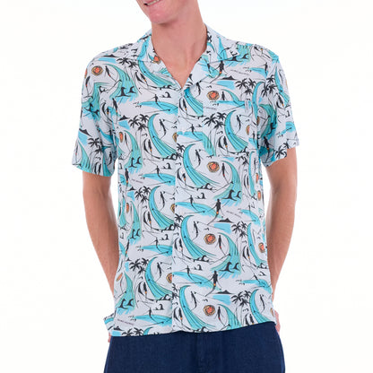 Person wearing a patterned shirt with dolphins and palm trees on a white background