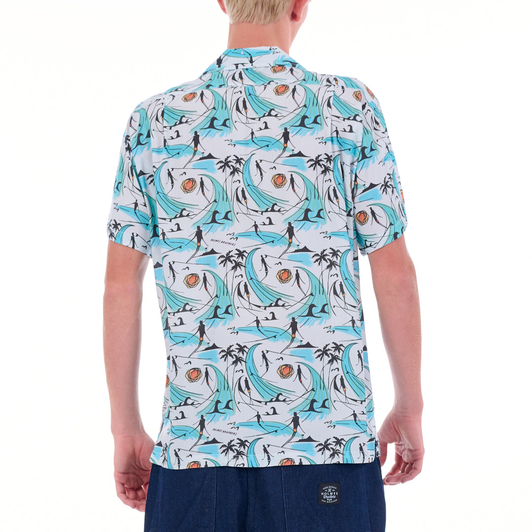 Person wearing a patterned shirt with blue waves and people on a white background