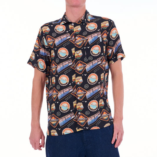 Person wearing a patterned shirt with colorful graphics on a white background