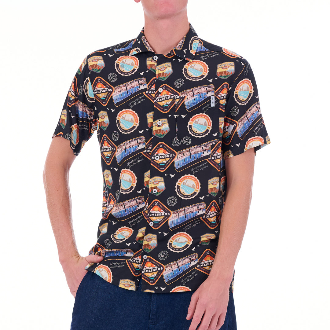 Person wearing a patterned shirt with various graphics on a white background