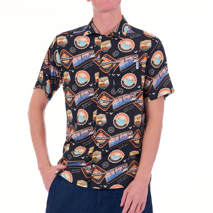 Person wearing a patterned shirt with various graphics on a white background