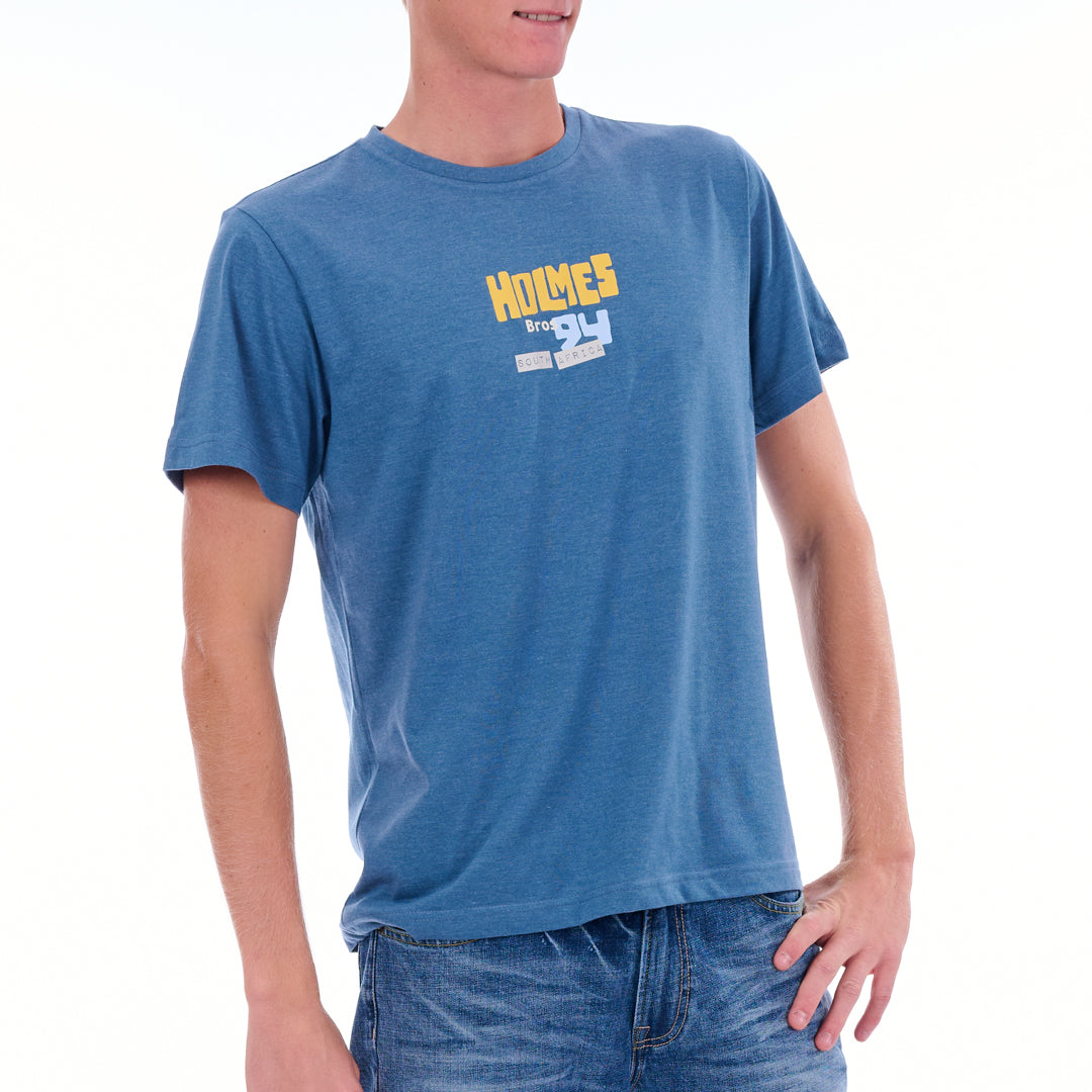 Person wearing a blue t-shirt with 'Holmes' logo on a white background