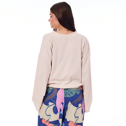 Woman wearing a beige sweater and colorful skirt on a white background