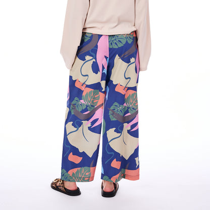 Person wearing colorful floral-patterned pants on a white background