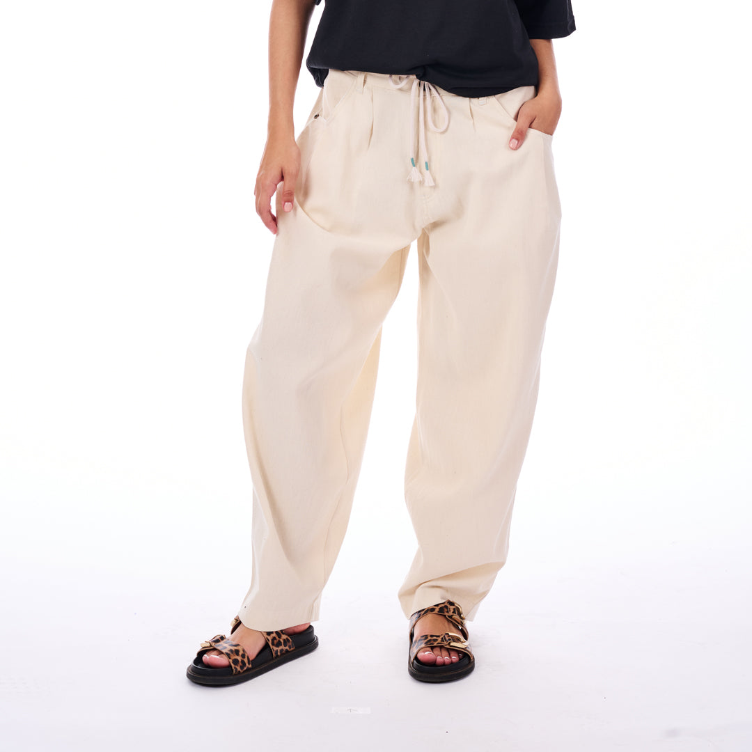 Person wearing beige drawstring pants on a white background