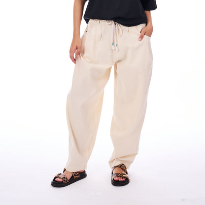 Person wearing beige drawstring pants on a white background