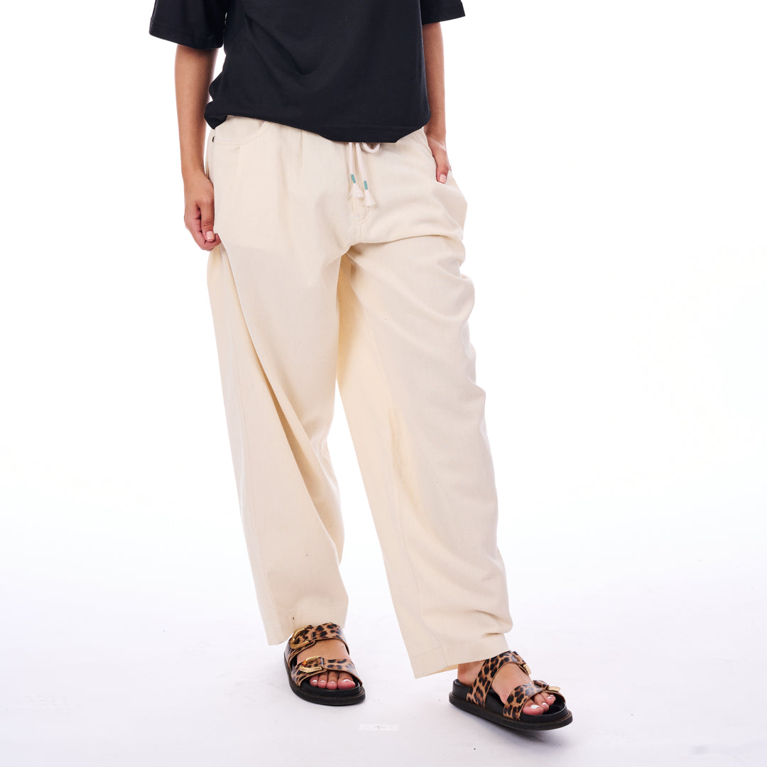 Person wearing beige pants and black sandals on a white background