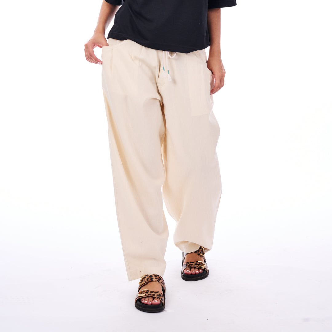 Person wearing beige pants and black sandals on a white background
