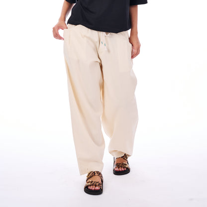 Person wearing beige pants and black sandals on a white background