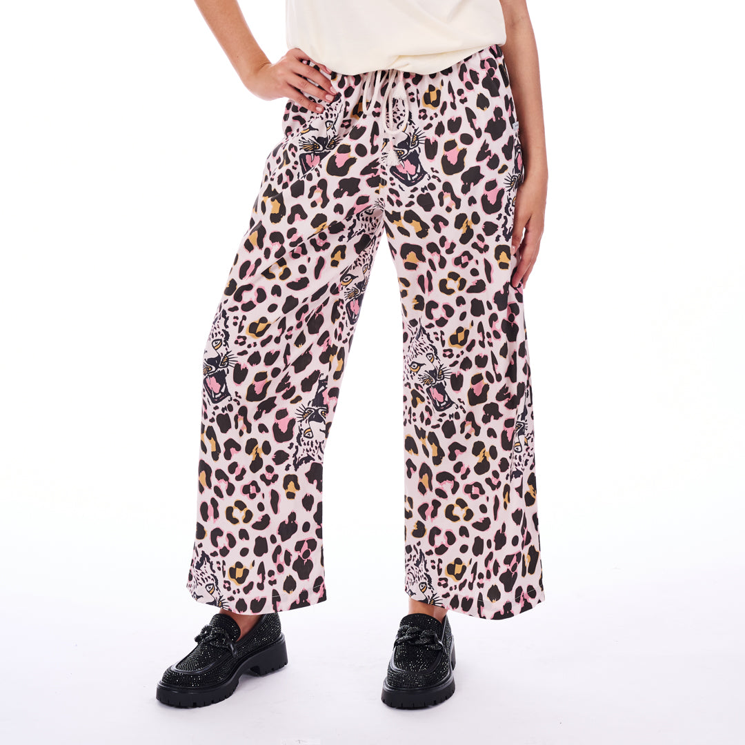 Person wearing leopard print pants on a white background