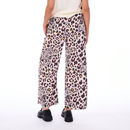 Person wearing wide-leg pants with a colorful animal print on a white background